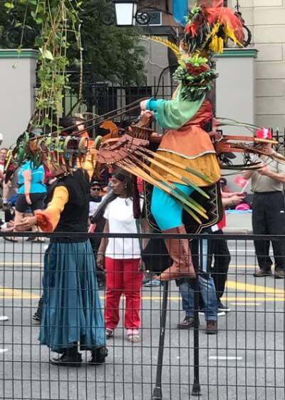 Stilt walker in a bird rider costume